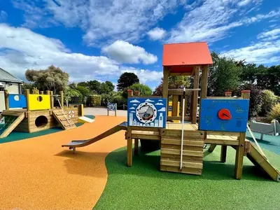 a playground with a slide and a play structure at H05 Par Sands in Tywardreath