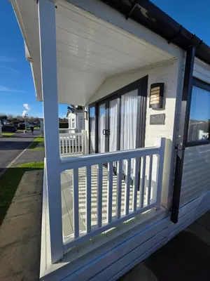 a porch of a house with a blue railing at H05 Par Sands in Tywardreath