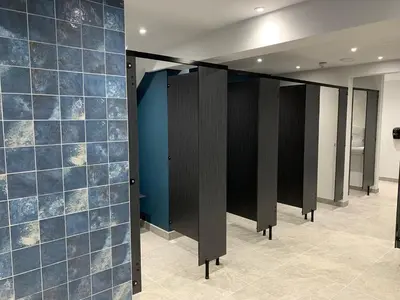 a row of stalls in a room with blue tiles at H05 Par Sands in Tywardreath