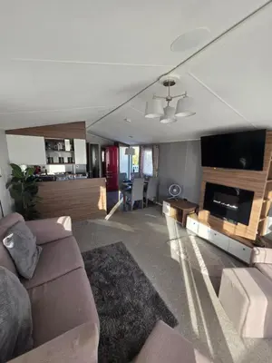 a living room with a couch and a flat screen tv at H05 Par Sands in Tywardreath