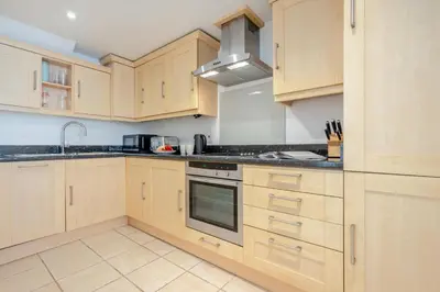 a kitchen with wooden cabinets and a stove top oven at 3 Bed in Polperro oc-h34100 in Polperro