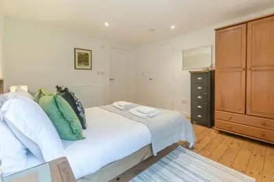 a bedroom with a large bed and a dresser at 3 Bed in Torpoint oc-l32511 in Downderry