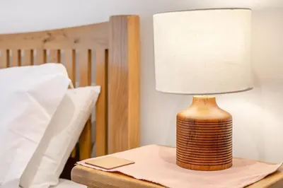 a lamp sitting on a table next to a bed at 3 Bed in Torpoint oc-l32511 in Downderry