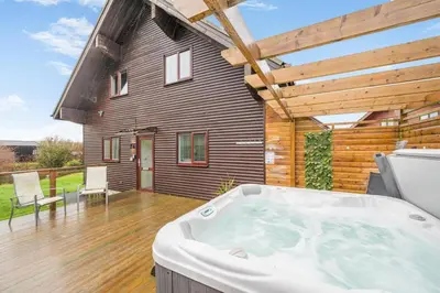 a hot tub on a deck with a house at 4 Bed in Winnards Perch oc-w34023 in Saint Columb Major