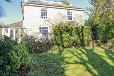 an old stone house with a green yard at Rosedale in St Ives