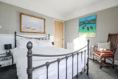 a bedroom with a bed and a chair at Rosedale in St Ives