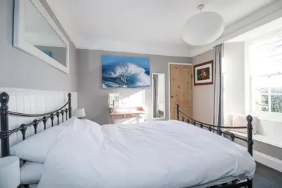 a bedroom with a large white bed and a window at Rosedale in St Ives