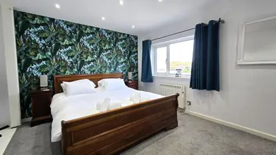 a bedroom with a large bed and a large window at Stepping Stones in Perranporth