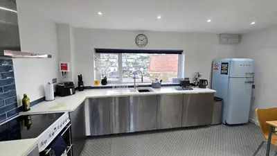 a kitchen with a sink and a refrigerator at Stepping Stones in Perranporth