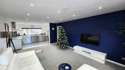 a living room with a christmas tree on a blue wall at Stepping Stones in Perranporth