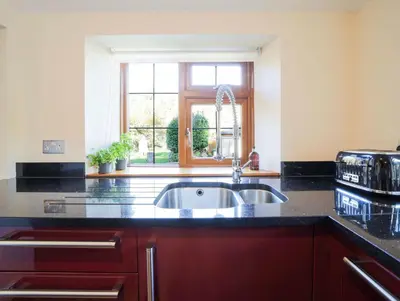 a kitchen with a sink and a window at Foxglove Cottage in Liskeard