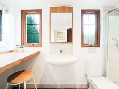 a white bathroom with a sink and a toilet at Foxglove Cottage in Liskeard
