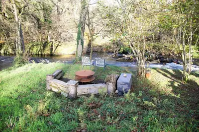 a toilet sitting on top of a stump in the grass at Foxglove Cottage in Liskeard