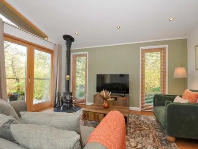 a living room with a couch and a tv at 6 Stonerush Valley in Looe