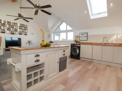 a kitchen with white cabinets and a ceiling fan at 33 Fordh Tobmen in St. Agnes