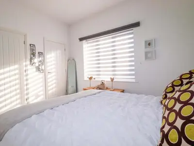 a bedroom with a large white bed and a window at 33 Fordh Tobmen in St. Agnes