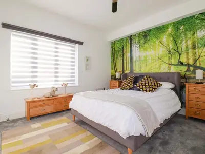 a bedroom with a large bed with a large painting on the wall at 33 Fordh Tobmen in St. Agnes