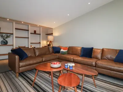 a living room with a brown couch and a table at Harberton in Wadebridge