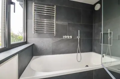 a bathroom with a white tub and a window at Harberton in Wadebridge