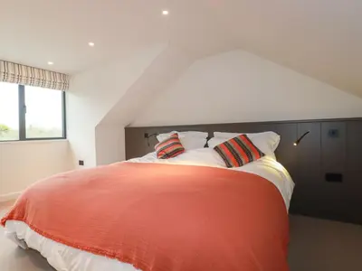 a bedroom with a red and white bed with pillows at Harberton in Wadebridge