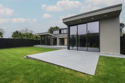 a house with large windows and a green yard at Harberton in Wadebridge