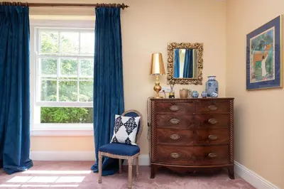 a bedroom with a dresser and a window at The Old Vicarage in Wadebridge