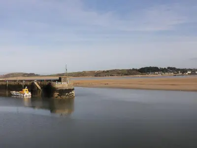 a boat in the water next to a pier at The Old Vicarage in Wadebridge