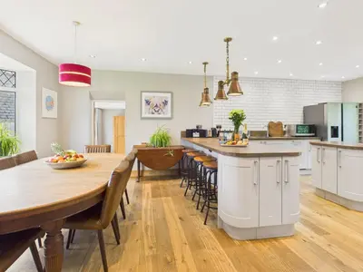 a kitchen and dining room with a table and chairs at Wyvern – Beautiful & Spacious 4-Bedroom Home with Parking & Gardens in Falmouth