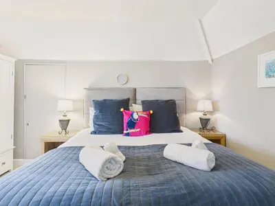 a bedroom with a large bed with towels on it at Wyvern – Beautiful & Spacious 4-Bedroom Home with Parking & Gardens in Falmouth