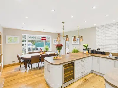 a kitchen with a table and a dining room at Wyvern – Beautiful & Spacious 4-Bedroom Home with Parking & Gardens in Falmouth