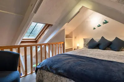 a bedroom with a large bed in a attic at Finest Retreats - Spray Barn in Saint Ervan