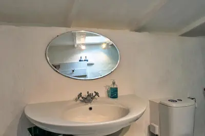 a bathroom with a sink and a mirror at Finest Retreats - Spray Barn in Saint Ervan