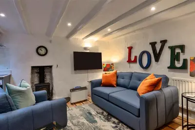 a living room with two blue couches and a tv at Finest Retreats - Spray Barn in Saint Ervan