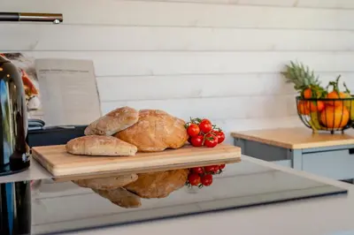 two loaves of bread and tomatoes on a cutting board at 1 Bed in Widegates oc-p34230 in Sheviock
