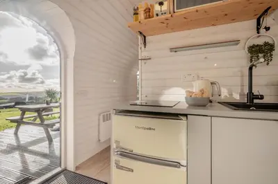a kitchen with a counter with a sink and a table at 1 Bed in Widegates oc-c34232 in Sheviock
