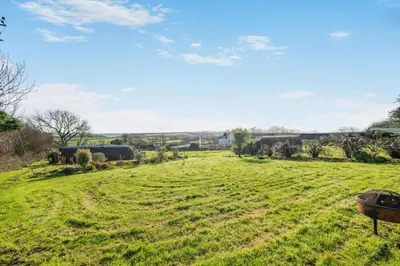 a field of grass with a train in the distance at 1 Bed in Widegates oc-c34232 in Sheviock