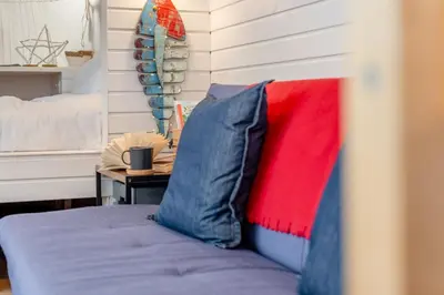 a bed with blue and red pillows next to a table at 1 Bed in Widegates oc-d34231 in Sheviock