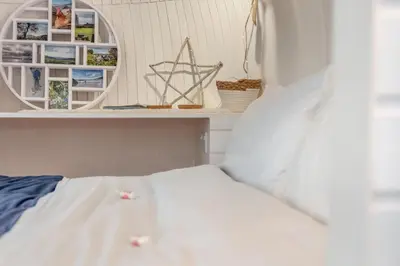 a bedroom with a white bed and a mirror at 1 Bed in Widegates oc-d34231 in Sheviock