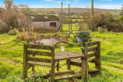 a wooden table and bench in a field at 1 Bed in Widegates oc-j34234 in Sheviock