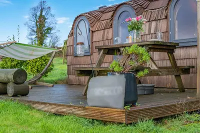 a wooden house with a hammock in front of it at 1 Bed in Widegates oc-p34233 in Sheviock