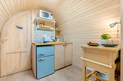 a small kitchen with a blue refrigerator and a table at 1 Bed in Widegates oc-p34236 in Sheviock