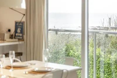 a dining room table with a view of the ocean at 4 Bed in Widemouth Bay oc-s34119 in Widemouth Bay