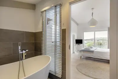 a bathroom with a tub and a bedroom with a bed at 4 Bed in Widemouth Bay oc-s34119 in Widemouth Bay