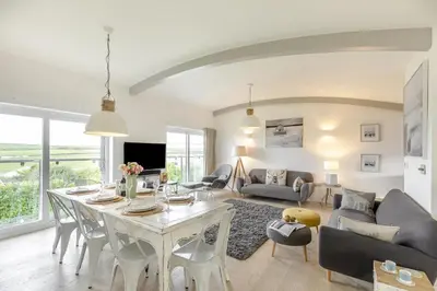 a living room with a table and chairs and a living room at 4 Bed in Widemouth Bay oc-s34119 in Widemouth Bay