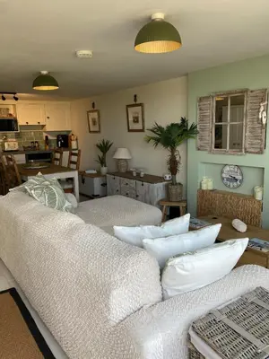 a living room with two white couches and a kitchen at Carrabee beachside haven for you & your pets in Saint Martin