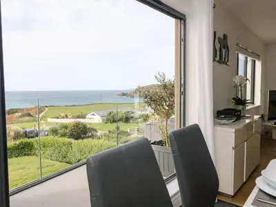 a dining room with a view of the ocean at Praa Waves in Penzance