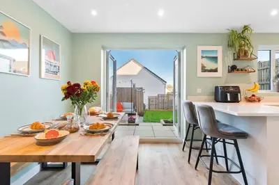 a kitchen and dining room with a table and chairs at Peaceful cottage near beaches - Bickland View in Falmouth