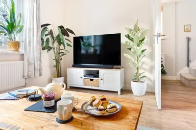 a living room with a table with a plate of food at Peaceful cottage near beaches - Bickland View in Falmouth
