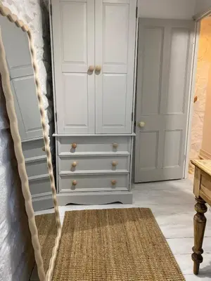a bedroom with a white dresser and a rug at SEA-AH-NA SIDE COTTAGE - Steps from the Beach Grade II Listed Refurbished Romantic Getaway in St Ives