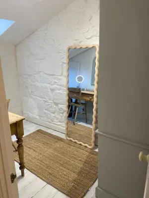 a mirror in the corner of a room with a desk at SEA-AH-NA SIDE COTTAGE - Steps from the Beach Grade II Listed Refurbished Romantic Getaway in St Ives
